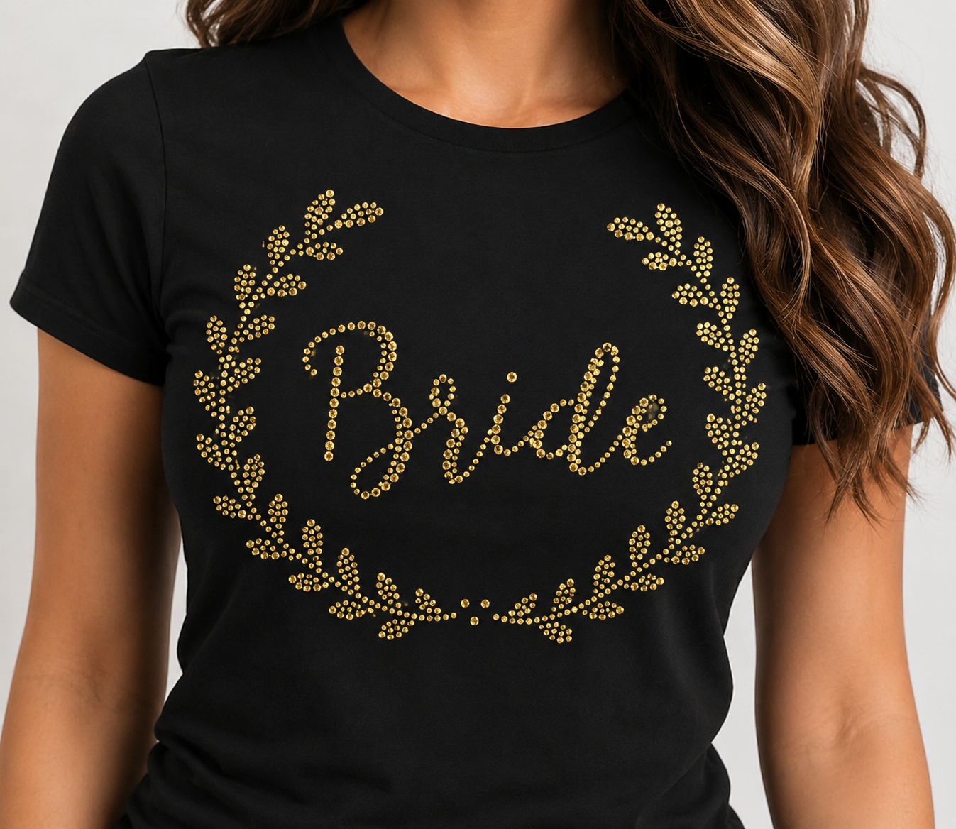 Close-up of a gold rhinestone Bride laurel wreath design on a black T-shirt